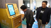 Direktur Utama BSI Hery Gunardi (kiri) didampingi Direktur Sales dan Distribution Anton Sukarna (kanan) melakukan transaksi pembelian emas melalui BSI ATM Emas Syariah di Gedung BSI, Jakarta.