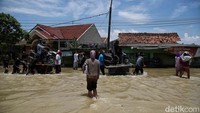 Ojek gerobak itu menyeberang dengan ditarik seorang warga. Sedangkan beberapa warga lainnya mendorong dari belakang.  