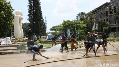 Petugas Damkar-Warga di Bekasi Gotong Royong Bersihkan Jalan dari Lumpur