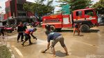 Petugas Damkar-Warga di Bekasi Gotong Royong Bersihkan Jalan dari Lumpur
