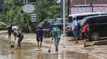 Petugas Damkar-Warga di Bekasi Gotong Royong Bersihkan Jalan dari Lumpur