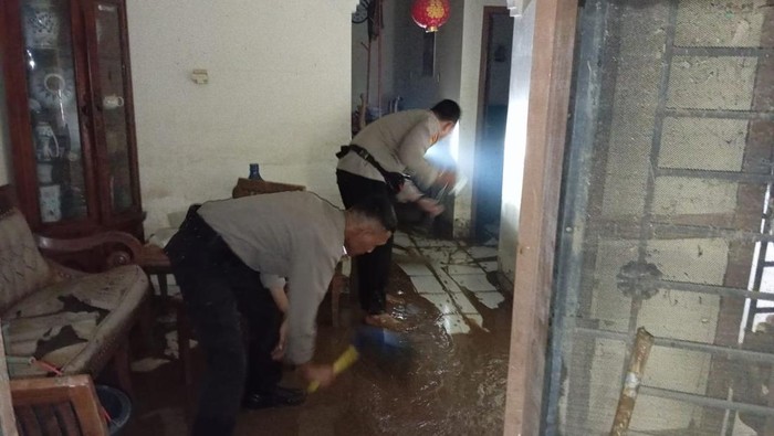 Polisi membantu mengeruk lumpur sisa banjir di Cawang, Banjir.