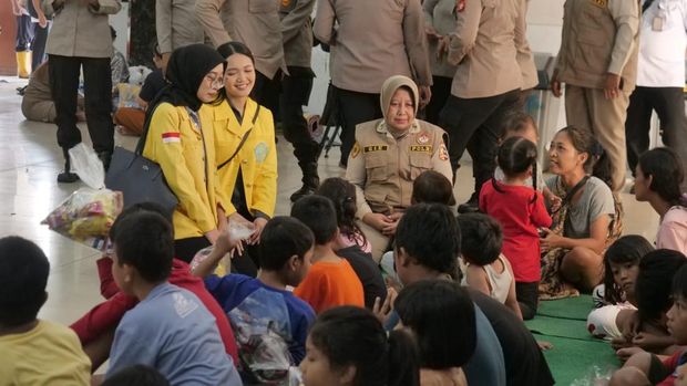 Polri mengajak mahasiswa UI, Belva Catalina D dan Dita Puspita, memberikan layanan trauma healing kepada warga korban banjir di Jakarta Timur, Rabu (5/3/2025).