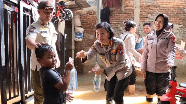 Polwan Polres Metro Jakarta Barat turun ke lokasi banjir di Kebon Jeruk membagikan sembako hingga snack bagi para korban.