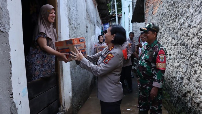 Polwan Polres Metro Jakarta Barat turun ke lokasi banjir di Kebon Jeruk membagikan sembako hingga snack bagi para korban.