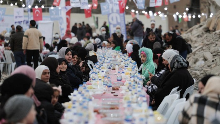 People gather amidst damaged buildings during Iftar (breaking of the fast), during the holy month of Ramadan, in Al-Qaboon neighborhood, Damascus, Syria, March 4, 2025. REUTERS/Khalil Ashawi