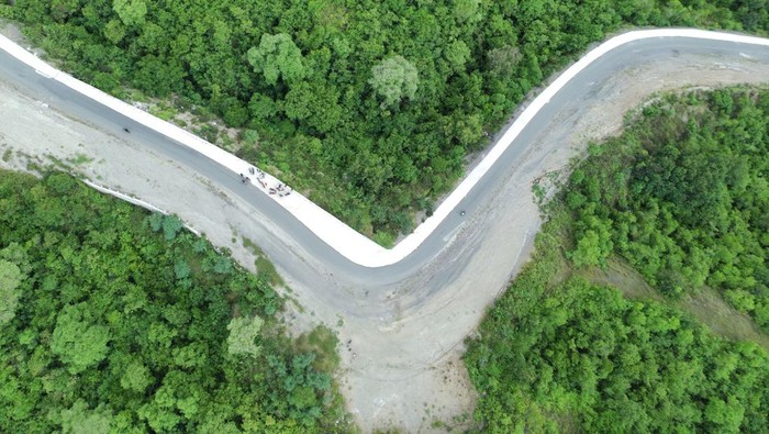 Potret Jalan Baru di Sigi yang Membelah Hutan Lindung Foto udara pengendara melintas di ruas jalan Bora-Pandere sepanjang 22 kilometer yang baru dibuka di Sigi, Sulawesi Tengah, Selasa (4/3/2025). Jalan yang menghabiskan anggaran sebesar Rp63 miliar itu sebagiannya adalah hasil pembebasan kawasan hutan lindung yang dikelola Balai Taman Nasional Lore Lindu (BTNLL) sepanjang 4,6 kilometer. ANTARA FOTO/Basri Marzuki/YU