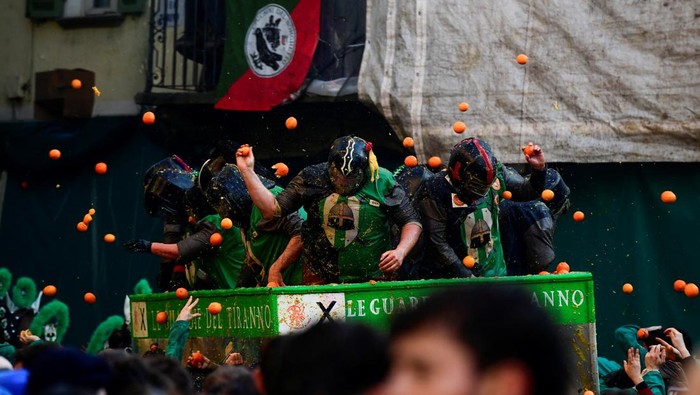 Potret Keseruan Tradisi Perang Jeruk di Italia Revellers take part in a fight with oranges during an annual carnival battle in Ivrea, Italy, March 2, 2025. REUTERS/Massimo Pinca