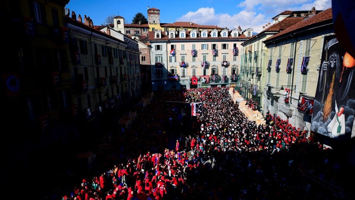 Potret Keseruan Tradisi Perang Jeruk di Italia Revellers take part in a fight with oranges during an annual carnival battle in Ivrea, Italy, March 2, 2025. REUTERS/Massimo Pinca