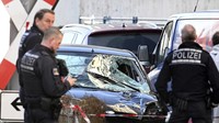 Petugas polisi berdiri di samping kendaraan yang rusak di pusat kota Mannheim, Jerman, Senin (3/3/2025). (Boris Roessler/dpa via AP)  