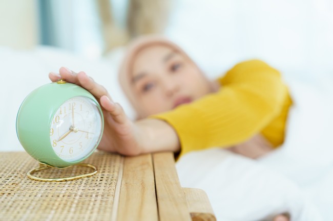 Ilustrasi tidur setelah makan sahur Beautiful Asian muslim young woman sleeping - relaxing on the bed during the day. Cozy and relaxing lifestyle of modern muslim woman concept.