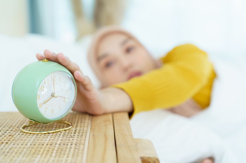 Beautiful Asian muslim young woman sleeping - relaxing on the bed during the day. Cozy and relaxing lifestyle of modern muslim woman concept.