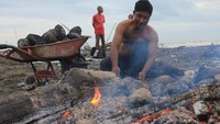 Pedagang musiman mengupas kelapa muda bakar di kawasan pantai Desa Peunaga Rayeuk, Kecamatan Meureubo, Aceh Barat, Aceh, Kamis (6/3/2025).  
