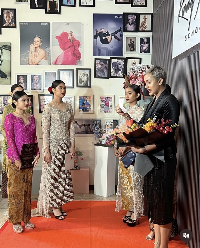 Rambut hitamnya tampak rapih terkonde dengan hiasan bunga mawar merah. Senada dengan aksesori di rambutnya, penampilan Almira juga terlihat semakin bold dengan pulasan lipstik berwarna merah marun. Foto: Instagram/@kimmyjayantischool