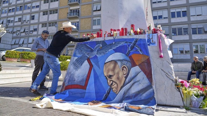 The Pope Francis painting made and displayed by Mexican painter Roberto Marquez lies on the floor outside the Agostino Gemelli in Rome, Wednesday, March 5, 2025. (AP Photo/Gregorio Borgia)