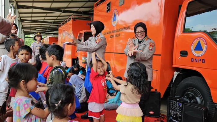 Polwan Polda Metro Jaya turun membantu memulihkan anak-anak di pengungsian pascabanjir di PGP, Kota Bekasi.