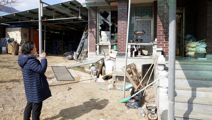 A police officer controls damaged area near the site of an accidental bombing in Pocheon, South Korea, Thursday, March 6, 2025. (AP Photo/Lee Jin-man)