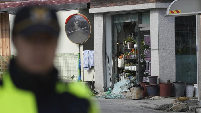 Potret Rumah Warga yang Rusak Akibat Bom yang Tak Sengaja Dijatuhkan Jet Tempur Korsel A police officer controls damaged area near the site of an accidental bombing in Pocheon, South Korea, Thursday, March 6, 2025. (AP Photo/Lee Jin-man)