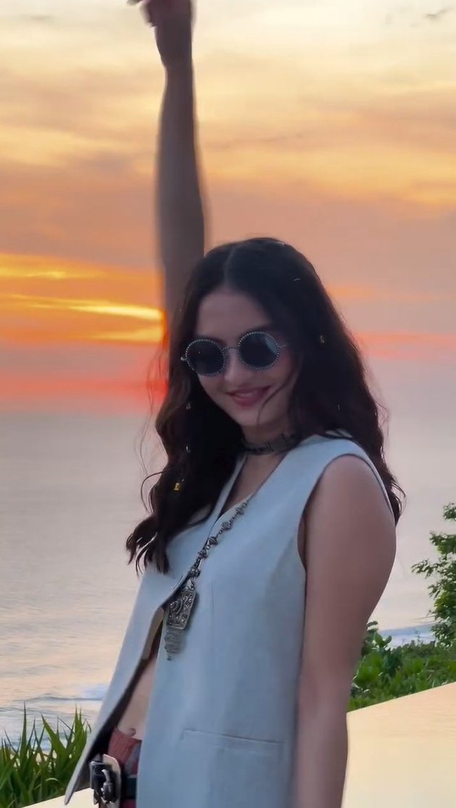 Ia memadukan vest yang memiliki bagian perut yang sedikit terlihat dengan celana panjang dan beberapa aksesori seperti kalung dan kaca mata hitam.  Foto: Instagram/@ralineshah