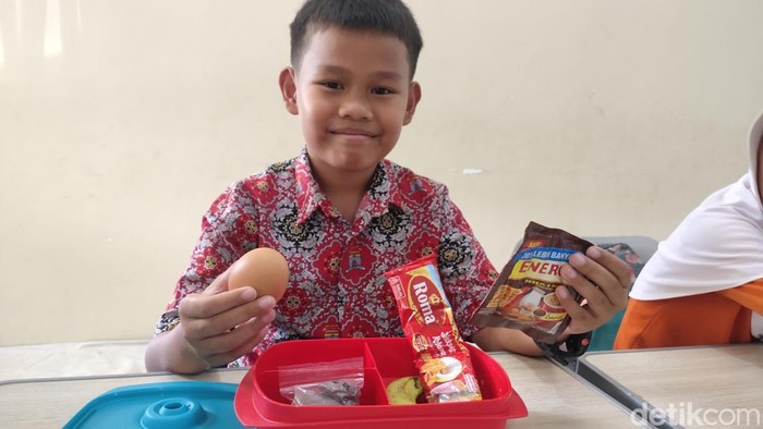 Salah satu siswa memperlihatkan menu MBG di SD Negeri 25 Palembang