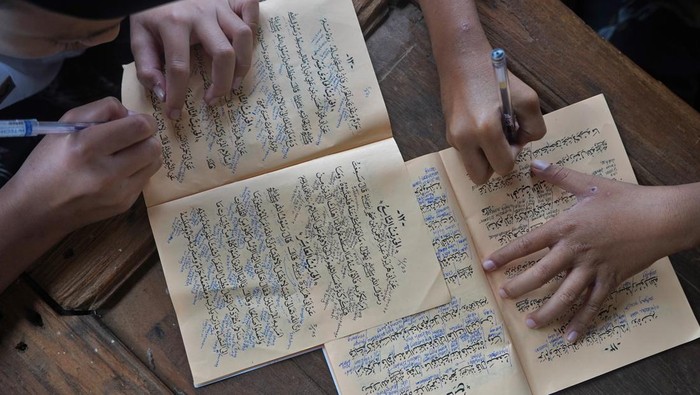 Sejumlah santri mengaji kitab Nashoihul Ibad saat Ngabuburit mengaji kitab kuning di kompleks Pondok Pesantren Al Musthofa Tebuireng 16 Wadas, Kandangan, Temanggung, Jawa Tengah, Kamis (6/3/2025). Selama bulan Ramadhan di ponpes tersebut santri diwaj