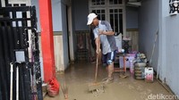 Warga membersihkan sisa lumpur di teras rumahnya.  