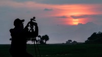 Pengunjung mengabadikan gambar matahari tenggelam disela-sela menunggu waktu berbuka puasa di padang sabana Pandanwangi, Kecamatan Tempeh, Lumajang, Jawa Timur.