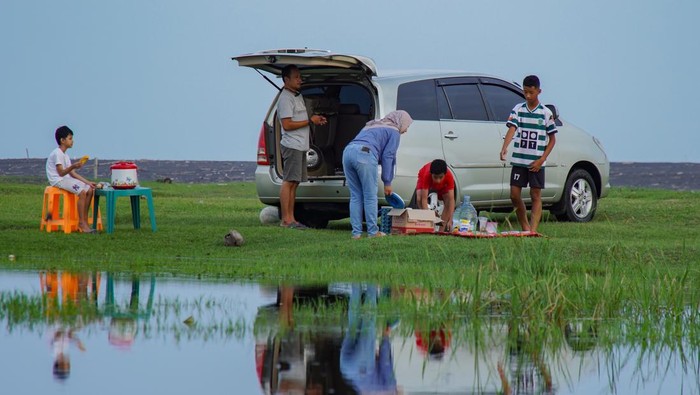 Warga menyiapkan makanan sebelum waktu berbuka puasa di padang sabana Pandanwangi, Kecamatan Tempeh, Lumajang, Jawa Timur, Rabu (5/3/2025). Padang sabana Pandanwangi yang terletak di pesisir selatan Kabupaten Lumajang tersebut menjadi salah satu tempat favorit bagi warga untuk menikmati suasana matahari terbenam dan menunggu waktu untuk berbuka puasa. ANTARA FOTO/Irfan Sumanjaya/agr
