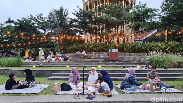 Warga ngabuburit dengan berpiknik di Taman Mini Indonesia Indah, Jakarta, Jumat (7/3/2025).