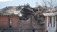 Seorang petugas forensik berjalan di dekat bangunan yang rusak setelah Angkatan Udara Korea Selatan mengatakan bahwa bom Mk82 jatuh dari jet KF-16 di luar lapangan tembak selama latihan tembak gabungan di dekat zona demiliterisasi yang memisahkan dua Korea di Pocheon, Korea Selatan, 6 Maret 2025. 