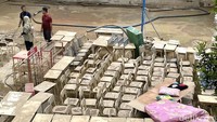 Di lapangan sekolah, terdapat deretan meja dan kursi yang penuh lumpur hingga buku pelajaran yang menggunung.  