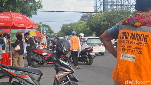 Juru parkir resmi Dishub Kota Mataram di area Sentra Kuliner Takjil Ramadan di Jalan Majapahit, Kota Mataram, Jumat (7/3/2025). (Nathea Citra/detikBali)