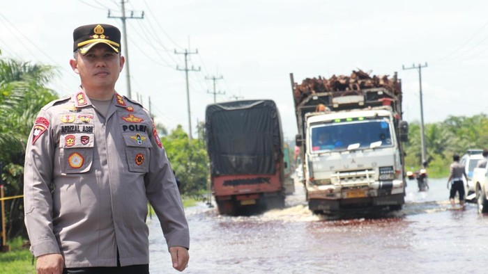 Kapolres AKBP Afrizal Asri mengecek jalan lintas timur KM 83 Desa Kemang, Pangkalan Kuras, Pelalawan yang mengalami banjir. (Dok. Polres Pelalawan)