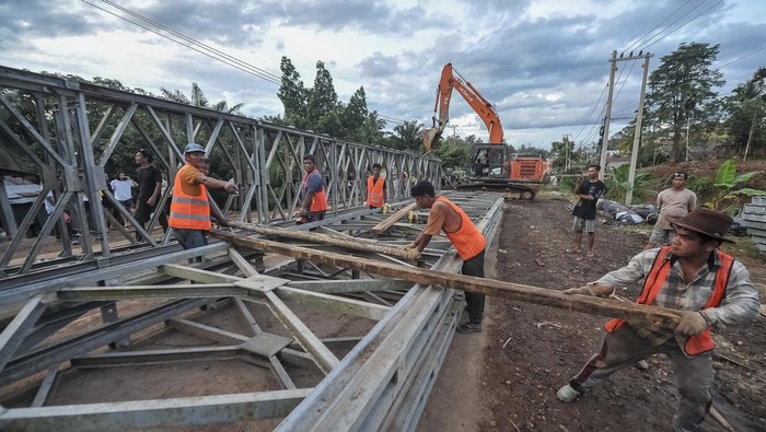 Pekerja merakit rangka jembatan darurat di Jalan Lintas Sumatera yang amblas, Desa Sirih Sekapur, Bungo, Jambi, Kamis (6/3/2025). Balai Pelaksana Jalan Nasional (BPJN) Jambi terus mengupayakan percepatan pemasangan tiang penyangga dan perakitan rangka jembatan darurat yang ditergetkan selesai pada Jumat (7/3) besok sehingga bisa dilakukan uji lalu lintas. ANTARA FOTO/Wahdi Septiawan/foc.