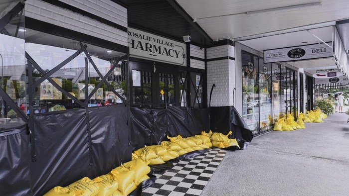 Warga Australia Bersiap Hadapi Topan Alfred Owners work to protect their cafe with sandbags and plastic sheets in the Brisbane suburb of Rosalie, Australia, Friday, March 7, 2025. (Jono Searle/AAP Image via AP)