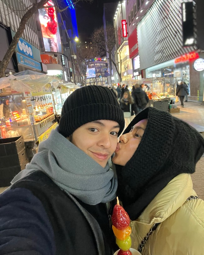 Dalam foto terbaru, Angga memamerkan momen manisnya dengan sang istri ketika menikmati tanghulu.  Foto: Instagram @angga