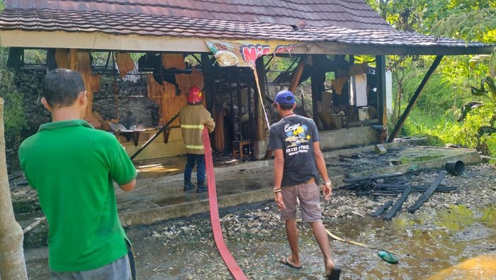 Petugas saat memadamkan api yang membakar warung makan di kawasan Pantai Kukup, Tanjungsari, Gunungkidul, Sabtu (8/3/2025).