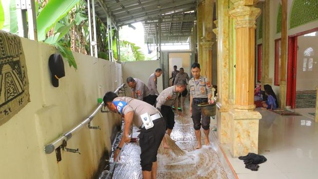 Polisi membantu membersihkan lumpur sisa banjir di masjid kawasan Babelan, Kabupaten Bekasi.