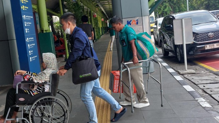 Tarmuji (47), pria berseragam biru yang bekerja sebagai porter di Stasiun Gambir, Jakarta Pusat. Tarmuji tak lelah menawarkan jasanya kepada setiap calon penumpang kereta api (KA) jarak jauh yang baru tiba di pintu masuk stasiun.