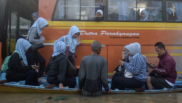 Potret Pekerja di Dayeuhkolot Naik Ojek Perahu Terobos Banjir Sejumlah pekerja turun dari bus dan beralih menggunakan jasa ojek perahu untuk melintasi banjir di ruas Jalan Raya Dayeuhkolot, Kabupaten Bandung, Jawa Barat, Sabtu (8/3/2025). Sebanyak 60 pekerja pabrik di kawasan tersebut terpaksa menggunakan jasa ojek perahu dengan membayar Rp5.000 hingga Rp10.000 per orang untuk melintas karena terdampak banjir luapan Sungai Citarum yang merendam jalan dan membuat sejumlah kendaraan mogok. ANTARA FOTO/Novrian Arbi/aww.