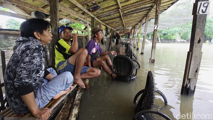 Para pemancing menunggu banjir surut di kolam pemancingan Galapung Kartika, Ciledug, Kota Tangerang, Banten, Minggu (9/3/2025).