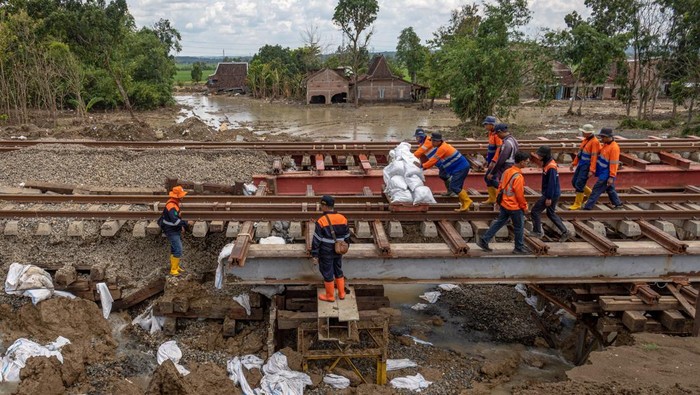 Jalur KA di Grobogan yang Terdampak Banjir Kembali Dilintasi Kereta Sejumlah pekerja PT Kereta Api Indonesia (Persero) Daop 4 Semarang mendorong lori berisi batu balas untuk meterial perbaikan jalur rel KA km 32+6/7 antara Stasiun Gubug - Karangjati yang sempat ditutup karena banjir luapan air Sungai Tuntang di Gubug, Kabupaten Grobogan Jawa Tengah, Minggu (9/3/2025). Jalur KA yang sempat ditutup sejak pukul 05:27 WIB akibat banjir itu pada pukul 12:08 WIB sudah bisa dilintasi KA Barang Peti Kemas No. 2529 relasi SurabayaβJakarta, disusul KA No. 1 Argo Bromo Anggrek pada pukul 12.08 WIB dengan kecepatan terbatas. ANTARA FOTO/Aji Styawan/Spt.