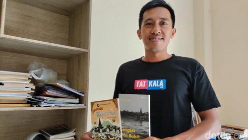 Komang Sujana menunjukkan dua buku antologi puisi berbahasa Bali miliknya. (Foto: Made Wijaya Kusuma/detikBali)