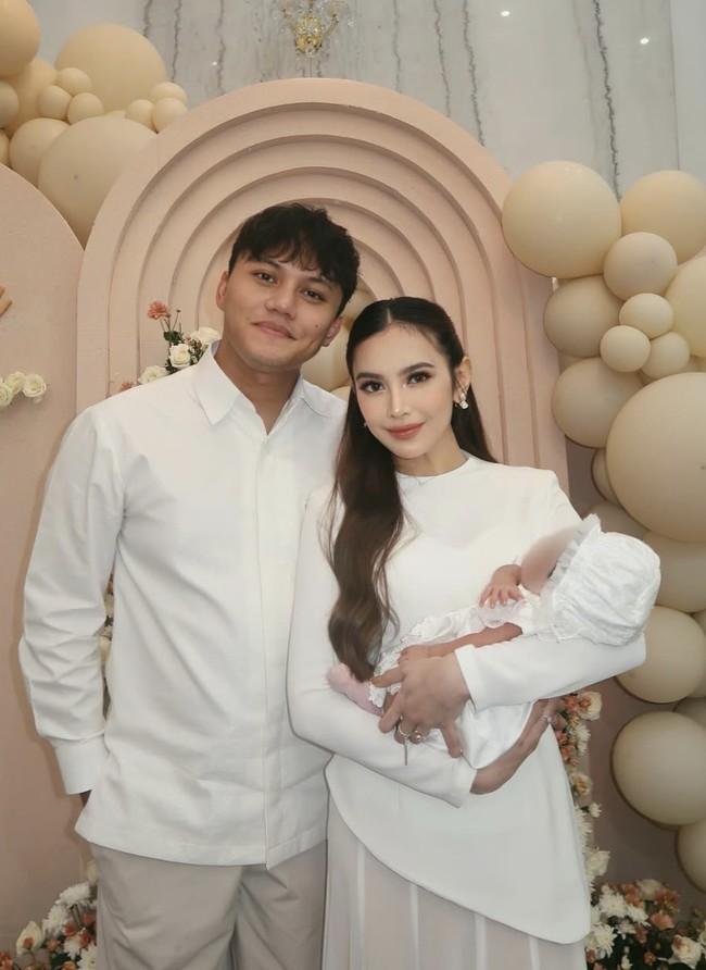 Acara akikah Baby Selina berlangsung dengan penuh khidmat. Dekorasi yang didominasi warna putih serta bunga-bunga segar menambah suasana sakral dalam momen ini. Rizky Febian dan Mahalini terlihat kompak dalam balutan busana putih yang dipesan mendadak, namun tetap terlihat elegan. Foto: dok. Instagram @mahaliniraharja