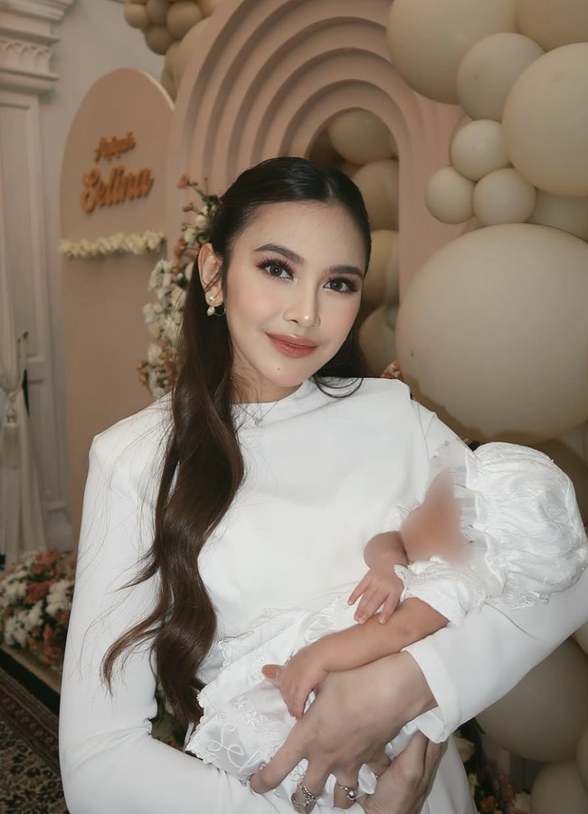 Selina lahir pada 15 Februari 2025 dengan nama lengkap Zairee Selina Quinlyn Kareema Febian. Si kecil tampil serasi mengenakan balutan dress putih yang serasi dengan ayah dan ibunya. Foto: dok. Instagram @mahaliniraharja