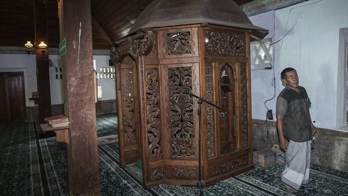 Pengurus masjid berjalan melewati mimbar di Masjid Jami Aulia Sapuro, Kota Pekalongan, Jawa Tengah, Minggu (9/3/2025). Masjid tertua di Kota Pekalongan ini diperkirakan dibangun pada tahun 1625 Masehi (1035 H) oleh empat utusan Demak yaitu Kiai Maksum, Kiai Sulaiman, Kiai Lukman, dan Kiai Kudung dengan masih terdapat empat kayu penyangga masjid yang berdiri kokoh hingga sekarang dan terdapat bagian kayu lainnya yang merupakan sisa pembangunan Masjid Agung Demak yang dibangun pada 1479 Masehi. 
ANTARA FOTO/Harviyan Perdana Putra/nz