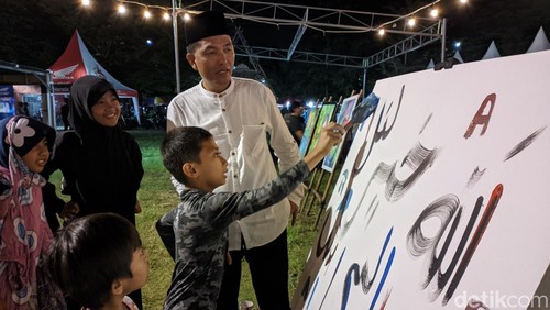 Anak-anak di Kota Mataram ikut belajar menulis mushaf Quran di Lapangan IC Mataram, Minggu (9/3/2025). (Ahmad Viqi/detikBali)