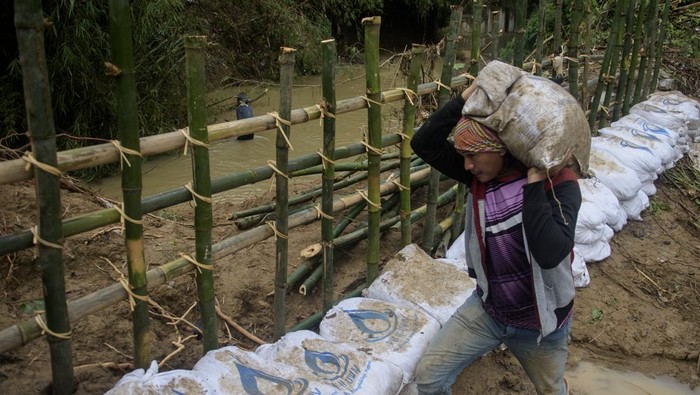 Warga memasang bambu dan pasir penahan di bantaran Sungai Cinangka di Cikaobandung, Purwakarta, Jawa Barat, Senin (10/3/2025). Warga bersama aparatur desa mulai membuat tanggul sementara menggantikan tanggul sepanjang 30 meter yang jebol untuk mengantisipasi terjadinya banjir luapan susulan saat intensitas hujan tinggi. ANTARA FOTO/Novrian Arbi/rwa.