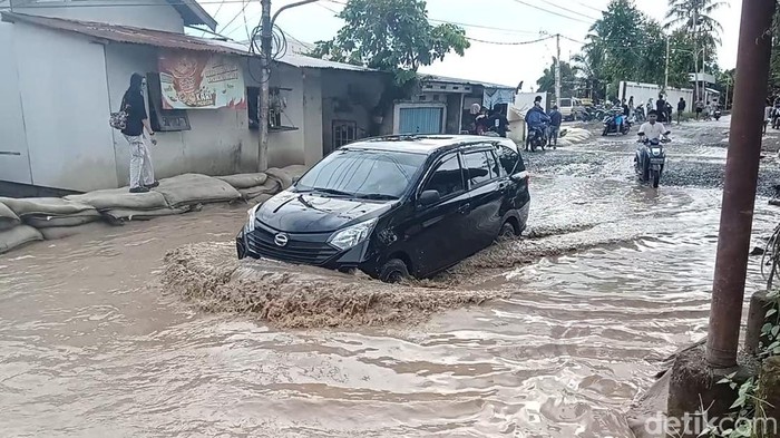 Jalan patah di Jalan Lettu Kadir, Kecamatan Gandus, Palembang yang dijanjikan akan diperbaiki Maret 2025. F