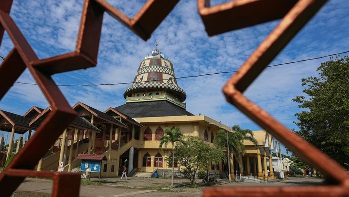 Melihat Masjid dengan Kubah Unik di Aceh Warga berjalan keluar dari Masjid Baitul Musyahadah di Desa Geuceu Kayee Jato, Banda Aceh, Aceh, Senin (10/3/2025). Masjid Baitul Musyahadah atau Masjid Kupiah Meukutop memiliki keunikan pada kubah hingga ornamen lainnya yang berbentuk kupiah (topi tradisional Aceh) atau juga disebut Kupiah Meukeutop yang kerap dipakai oleh pahlawan nasional Aceh, Teuku Umar. ANTARA FOTO/Khalis Surry/rwa.